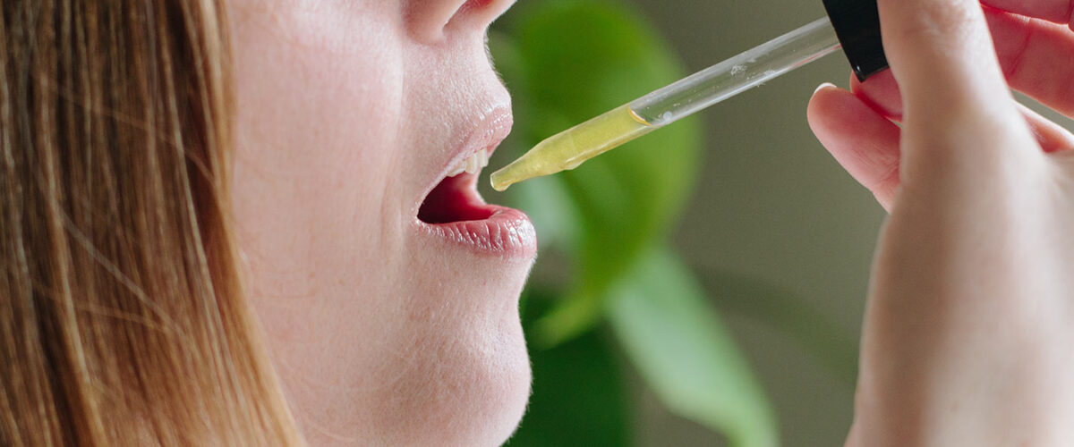 woman using hemp oil drops